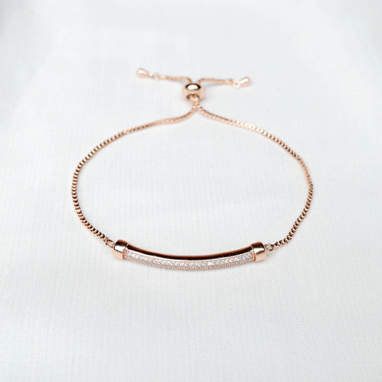 Elegant rose gold bracelet with a slim bar and sparkling crystal accents on a white background