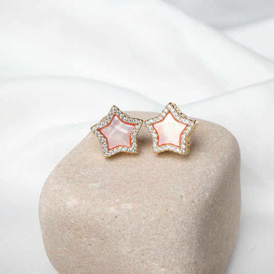 QuinShine rose gold star earrings with mother of pearl center and crystal accents on beige stone