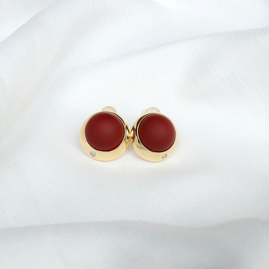 QuinShine scarlet sphere stud earrings with gold setting and small diamond detail on white fabric