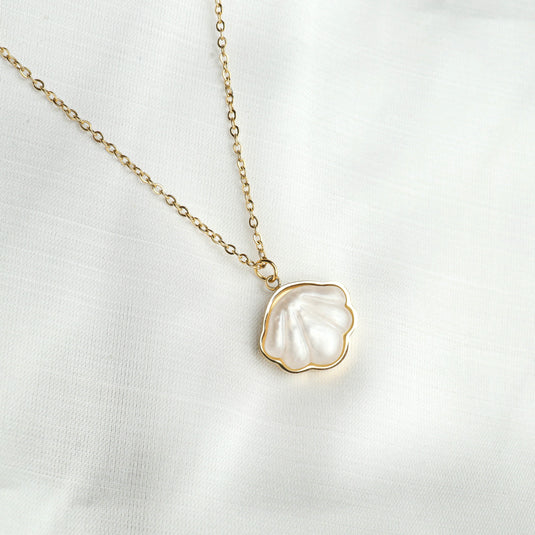 Delicate gold chain necklace with a white seashell pendant featuring gold trim Seashell Pendant Jewelry