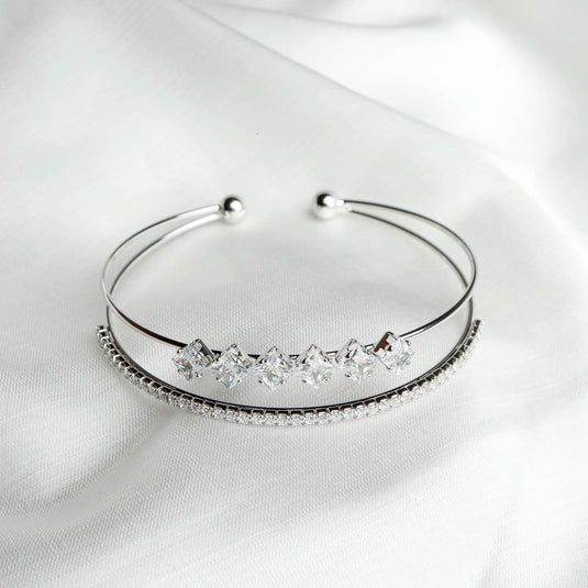 QuinShine elegant crystal-studded bracelet with two silver bands and sparkling clear stones on white fabric