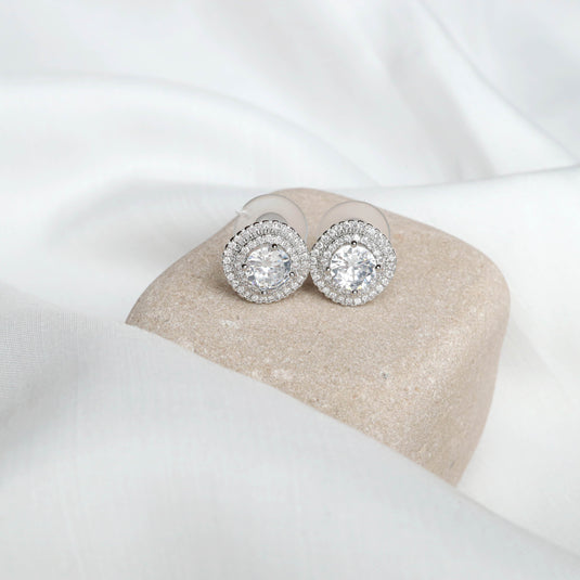 QuinShine silver halo earrings with sparkling round crystals on beige stone display