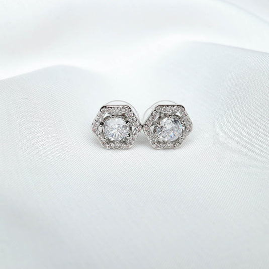 QuinShine elegant hexagon stud earrings with sparkling clear stones on white fabric background