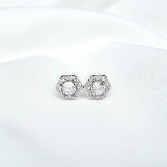 QuinShine elegant hexagon stud earrings with sparkling central stones on white fabric