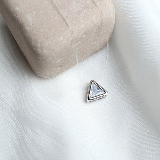 QuinShine elegant transparent chain necklace with a triangular silver pendant on white fabric