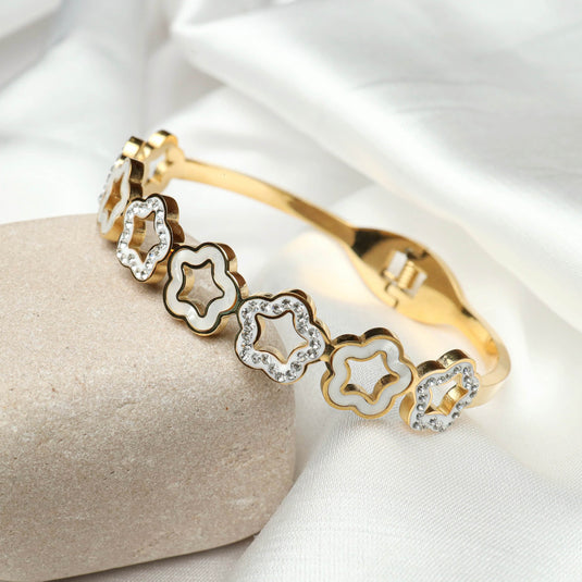QuinShine gold bracelet with unique floral jewelry design featuring white enamel and sparkling stones