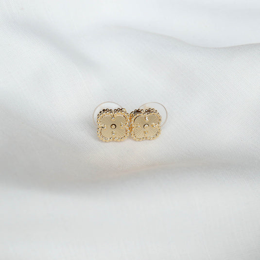 QuinShine unique gold stud earrings with intricate beaded square design on white fabric