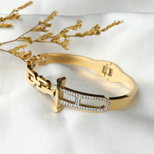 QuinShine golden equinox bracelet with gold finish and crystal accents on white fabric background