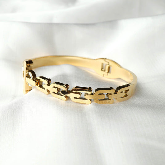 QuinShine golden equinox bracelet with interlocking chain design on white fabric background