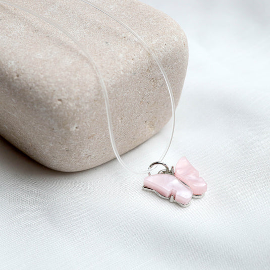 QuinShine pastel butterfly necklace with a delicate pink butterfly pendant on a clear cord