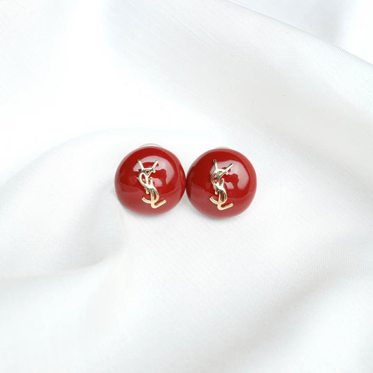 QuinShine red domed earrings for women with gold decorative accents on white fabric
